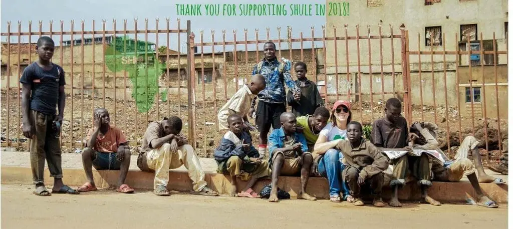 A group of people sitting on the side of a road.