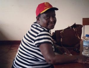 A woman sitting at the piano wearing a red hat.