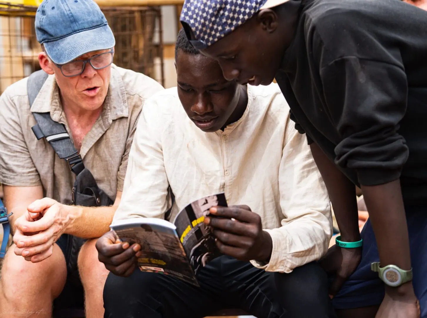 A group of people sitting around looking at magazines.