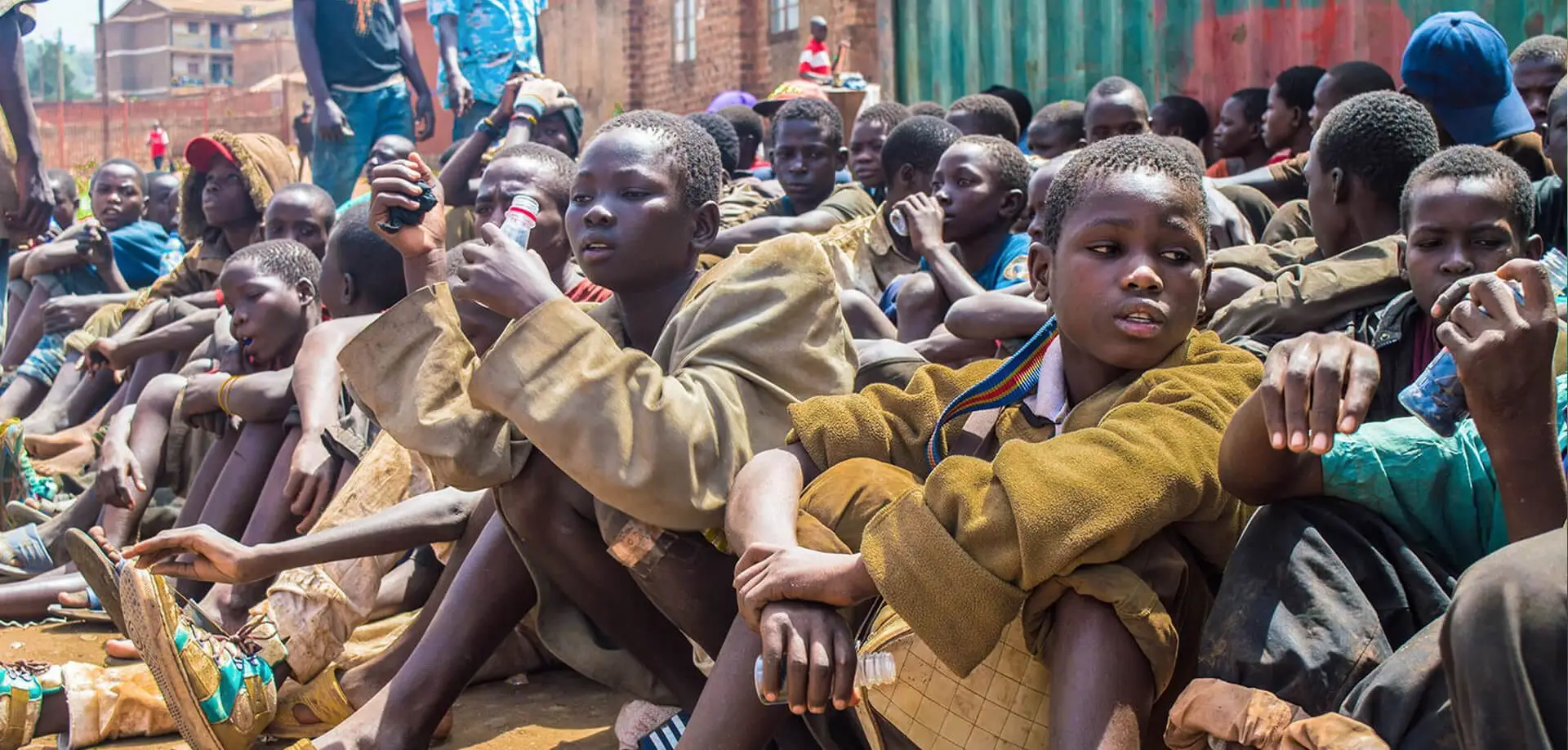 Group of children sitting on ground.